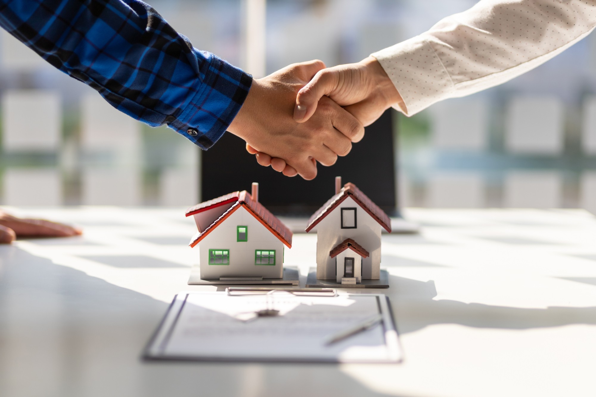 Cierre de acuerdo inmobiliario con maquetas de casas